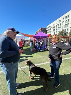 Adopters meeting a dog at an outdoor event.