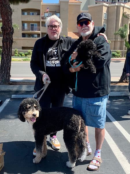 Two men in CDR shirts with a bernedoodle.