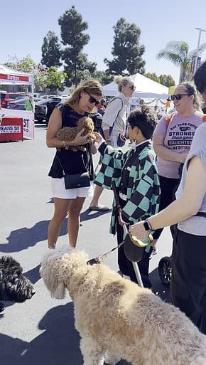 Woman holding a puppy at a pet event.